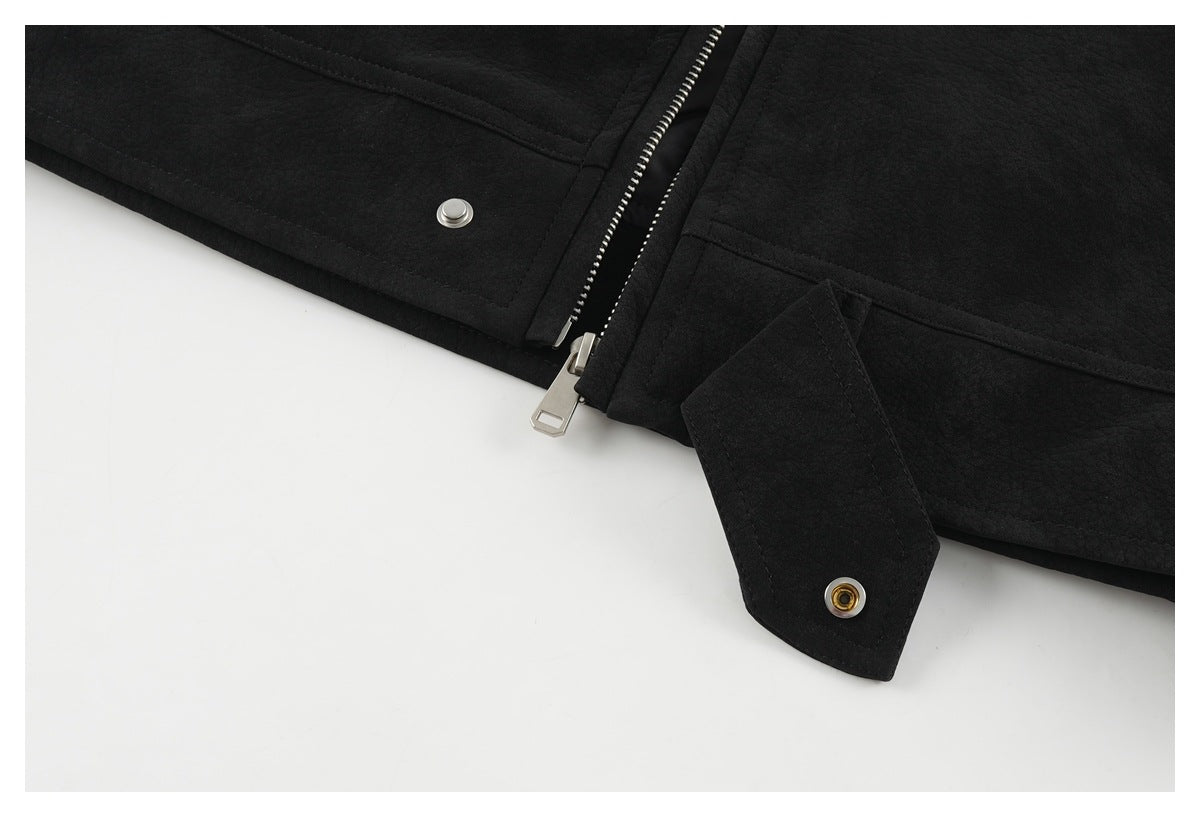 Close-up of the black jacket's silver front zipper, snap fasteners, and lower fastening tab.
