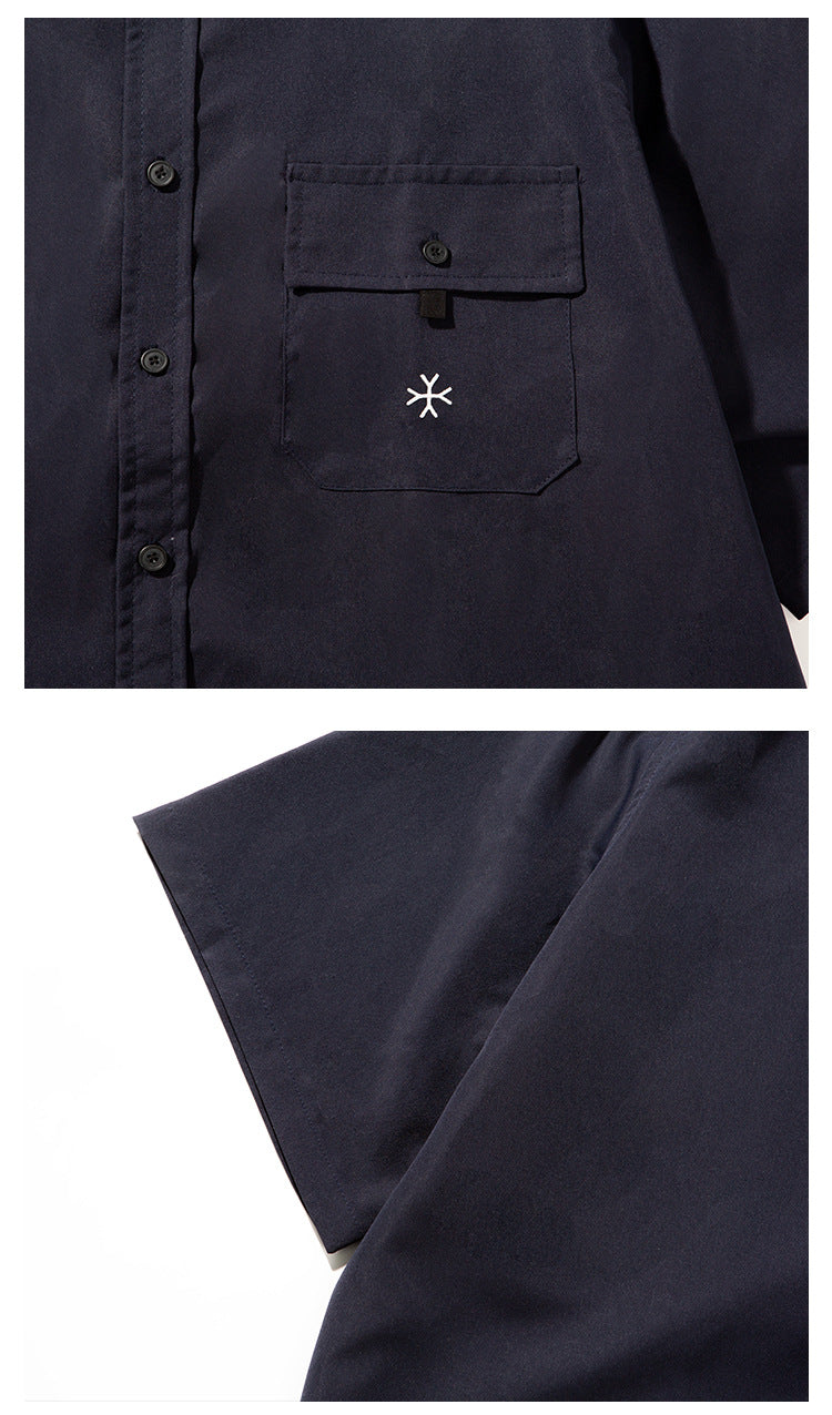 Close-up of a navy shirt's buttoned chest pocket and wide short sleeve.