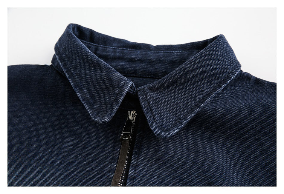 Close-up of a navy garment's pointed collar and front zipper.