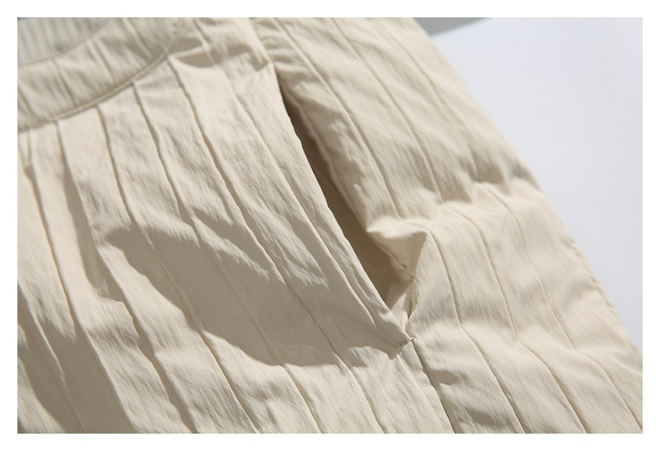 Close-up of the cream jacket’s crinkled panel seams and folded fabric.