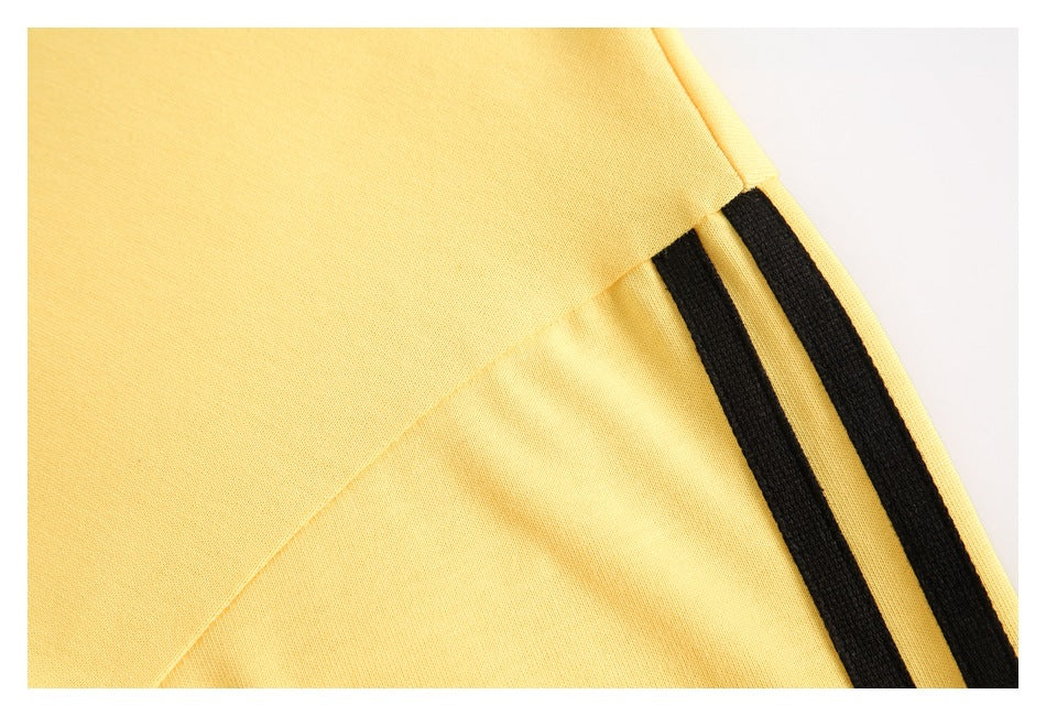 Close-up of two black stripes along a seam on yellow fabric.