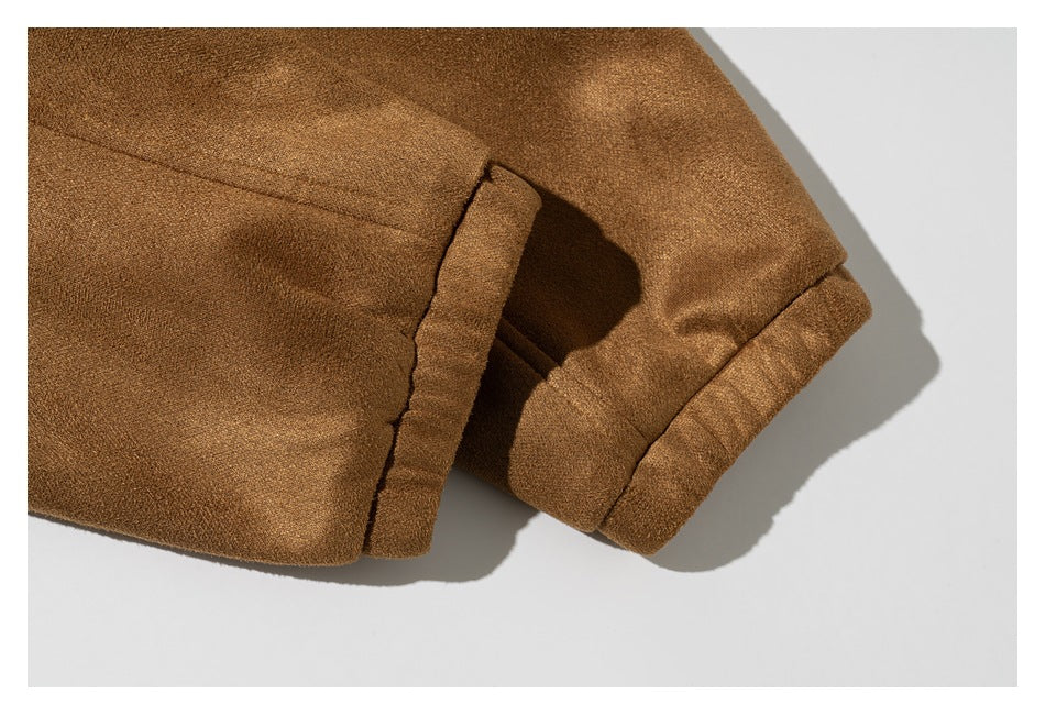 Close-up of a camel-brown coat sleeve cuff and adjacent seam.