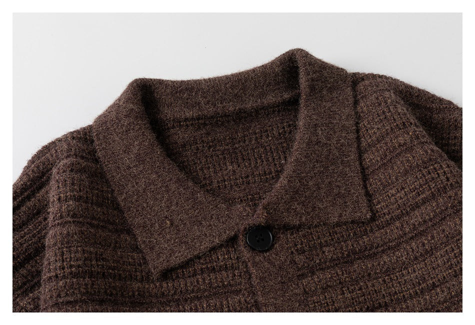 Close-up of a dark brown textured knit sweater with a wide collar and black button.