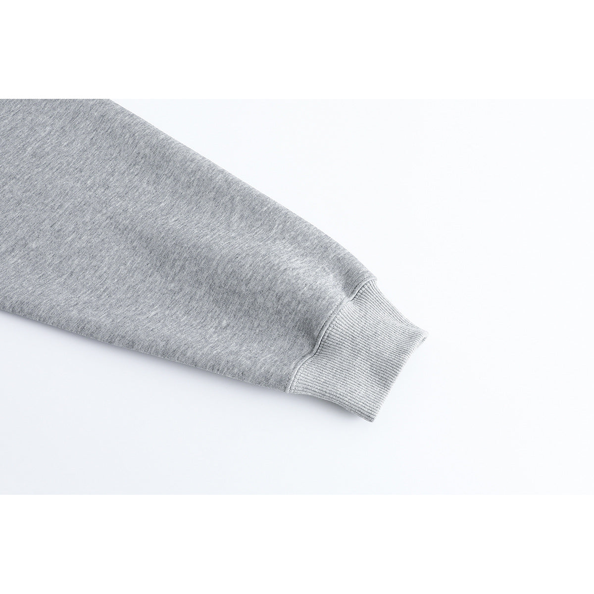 Close-up of a heather gray sweatshirt sleeve ending in a ribbed cuff.