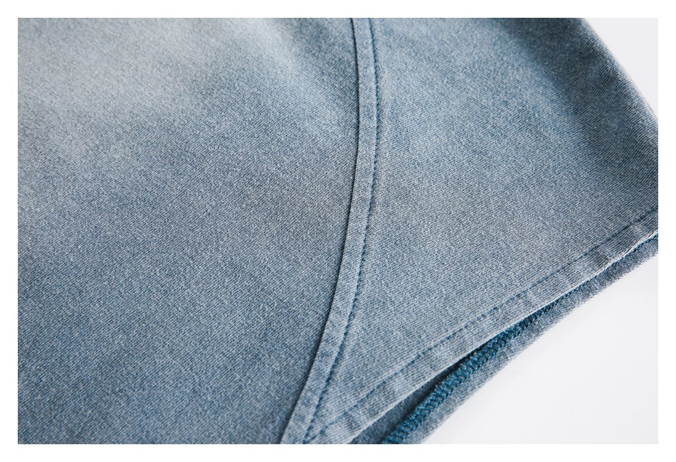 Close-up of blue-gray knit fabric showing a curved seam and stitched edge.