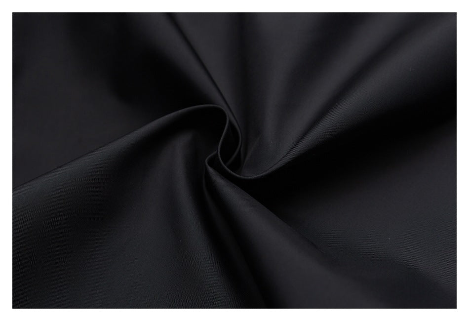 Close-up of smooth black fabric arranged in soft folds.