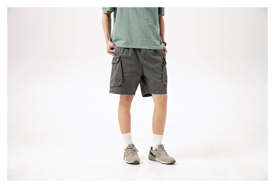 Front view of a model wearing charcoal gray cargo shorts with flap pockets.
