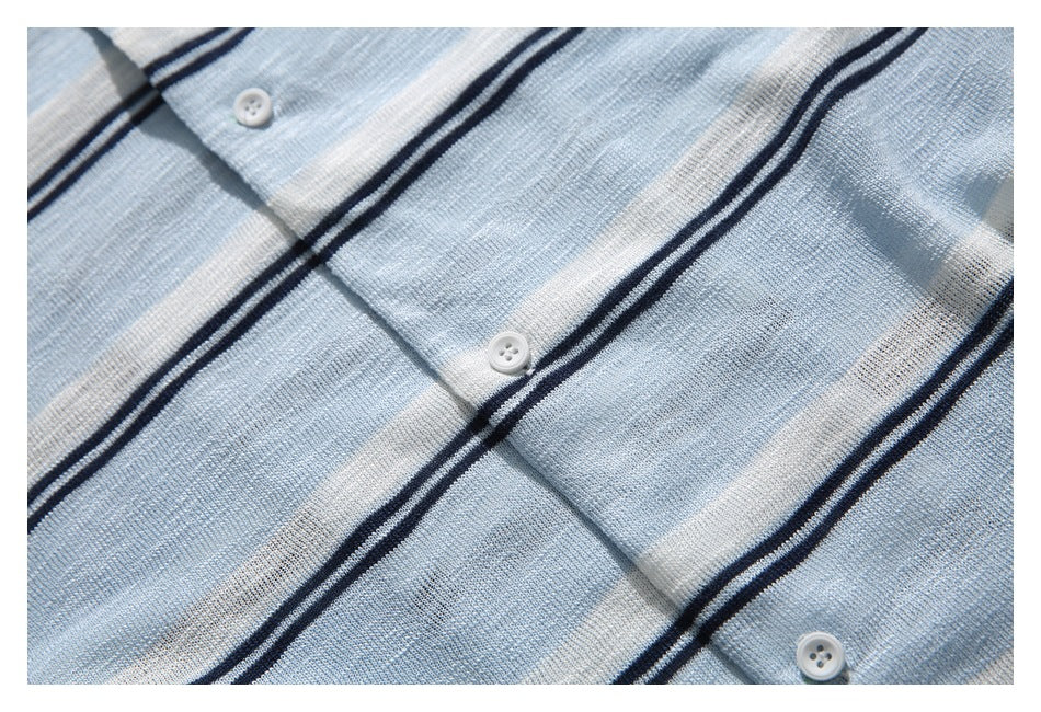 Close-up of a light blue striped knit garment placket with three small white buttons.