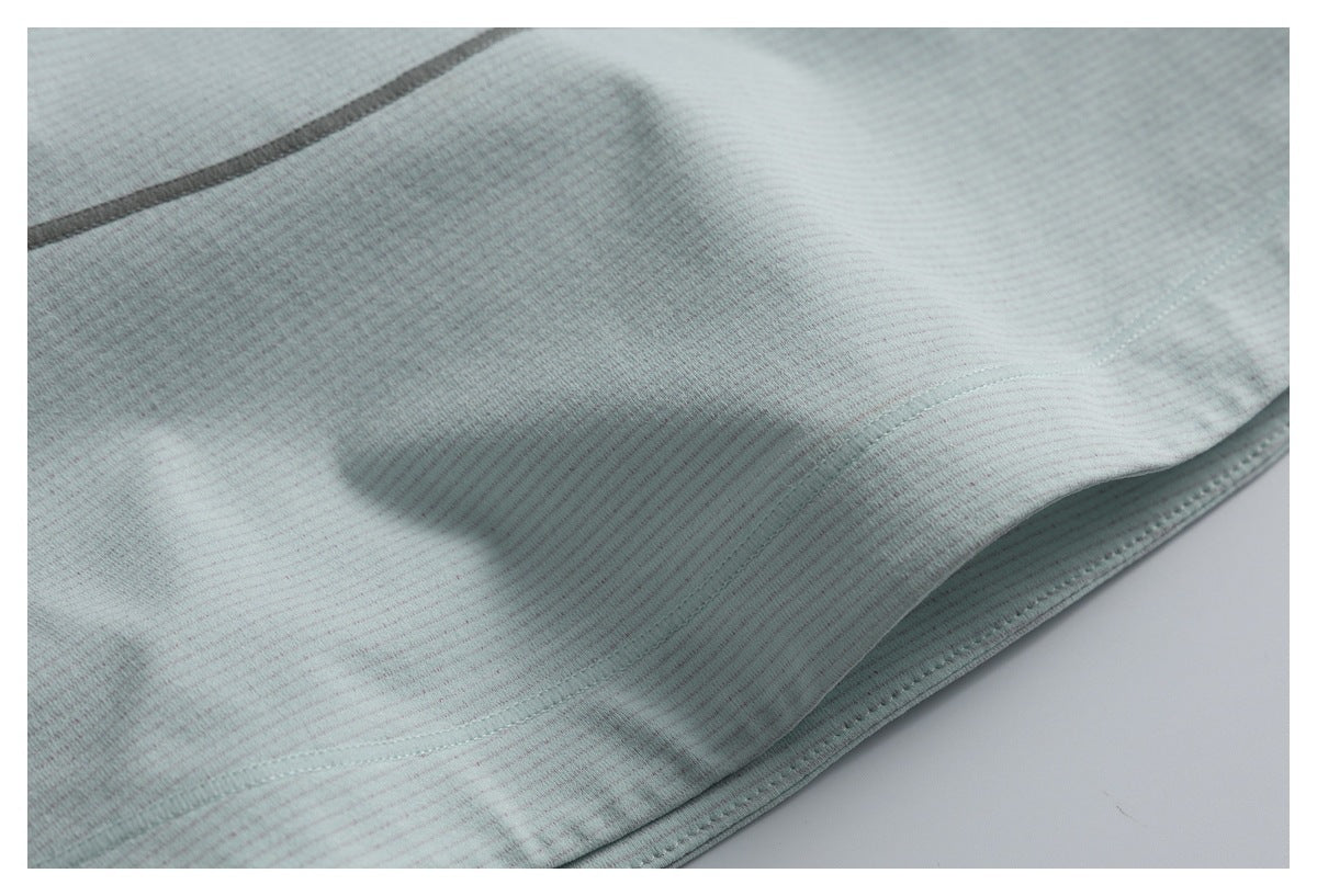 Close-up of pale mint-gray finely striped fabric with a curved seam and stitched hem.