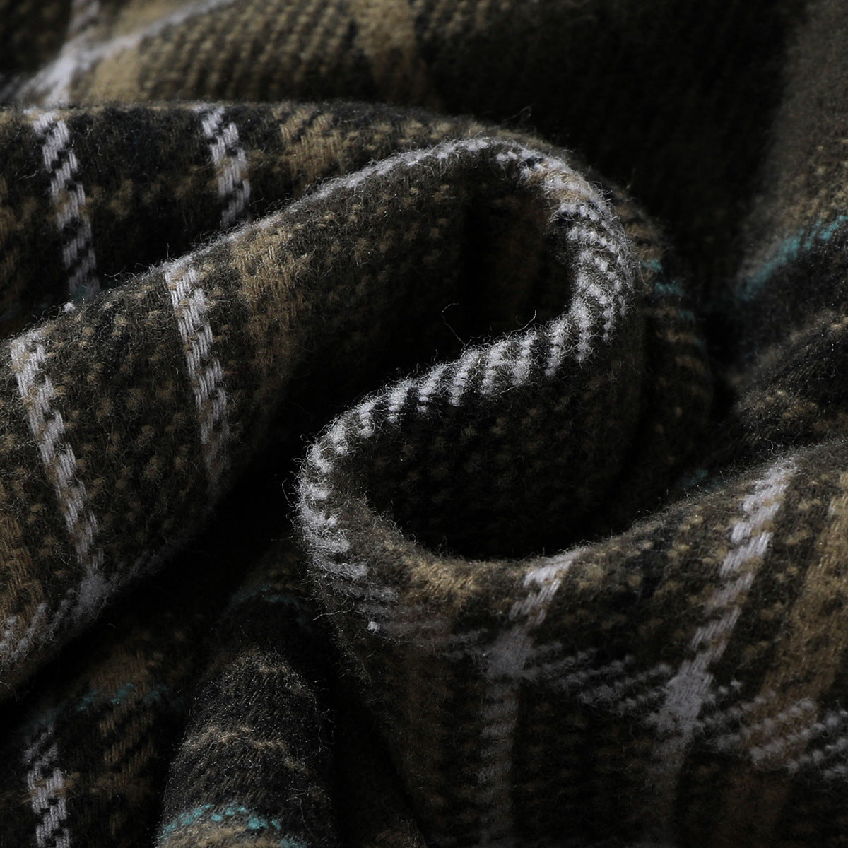 Extreme close-up of the dark plaid shirt fabric, showing its woven pattern and fuzzy surface.