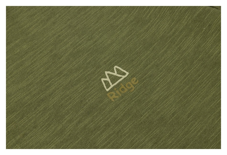 Close-up of a small cream and tan graphic printed on olive green textured T-shirt fabric.