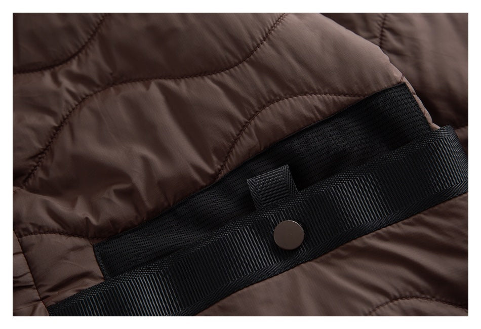 Close-up of brown quilted jacket with a black ribbed trim band and snap.