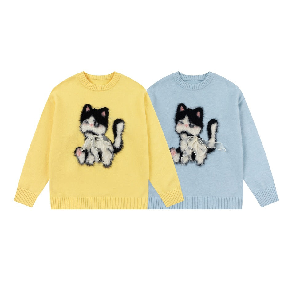 Yellow and light blue sweaters displayed together, each with a fluffy black-and-white cat applique and bow.