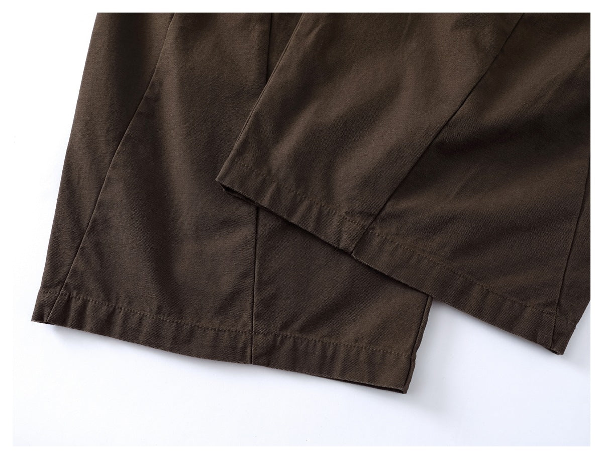 Close-up of dark brown trouser leg hems and stitching.