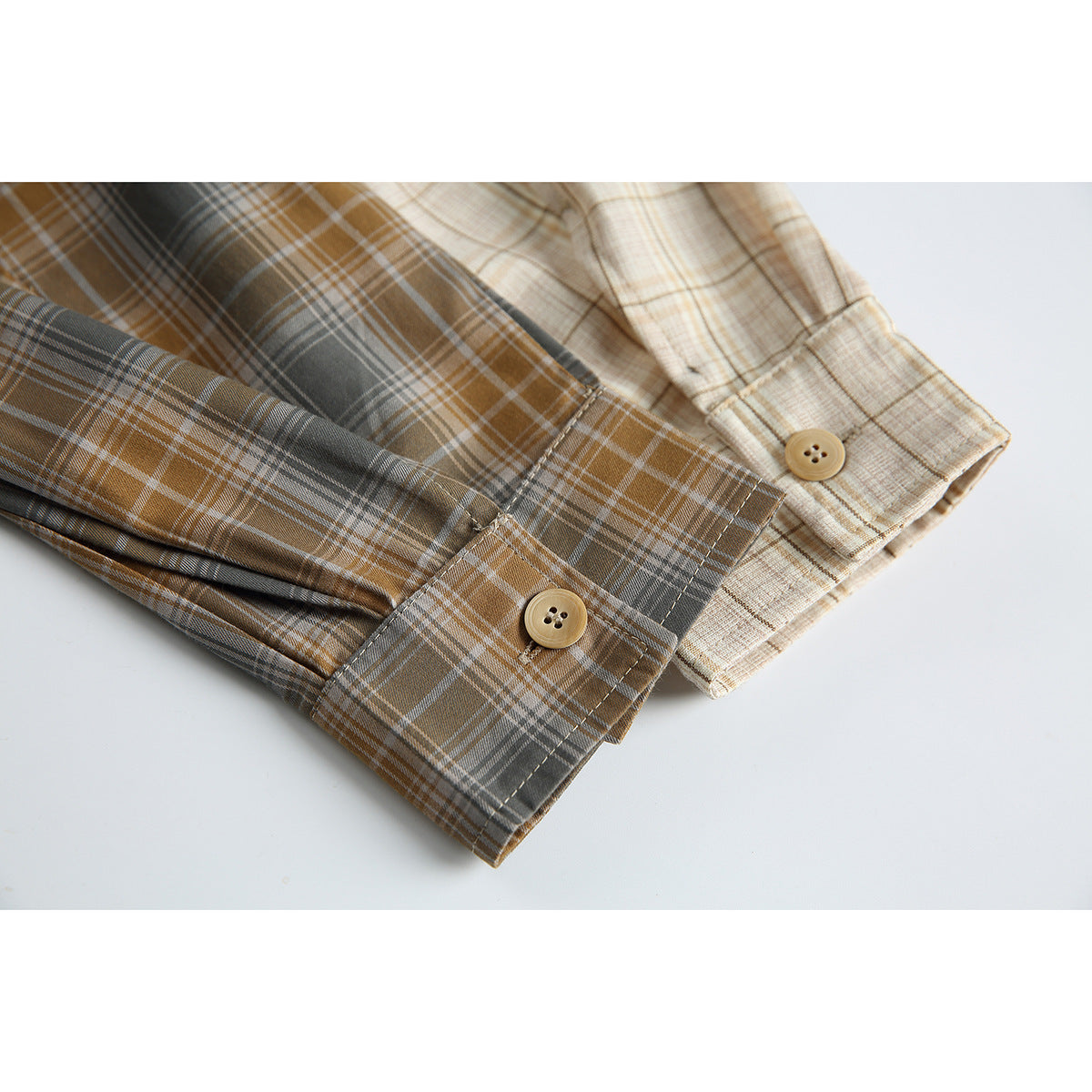 Close-up of the shirt's plaid sleeve cuffs, showing contrasting cream and gray patterns and buttons.