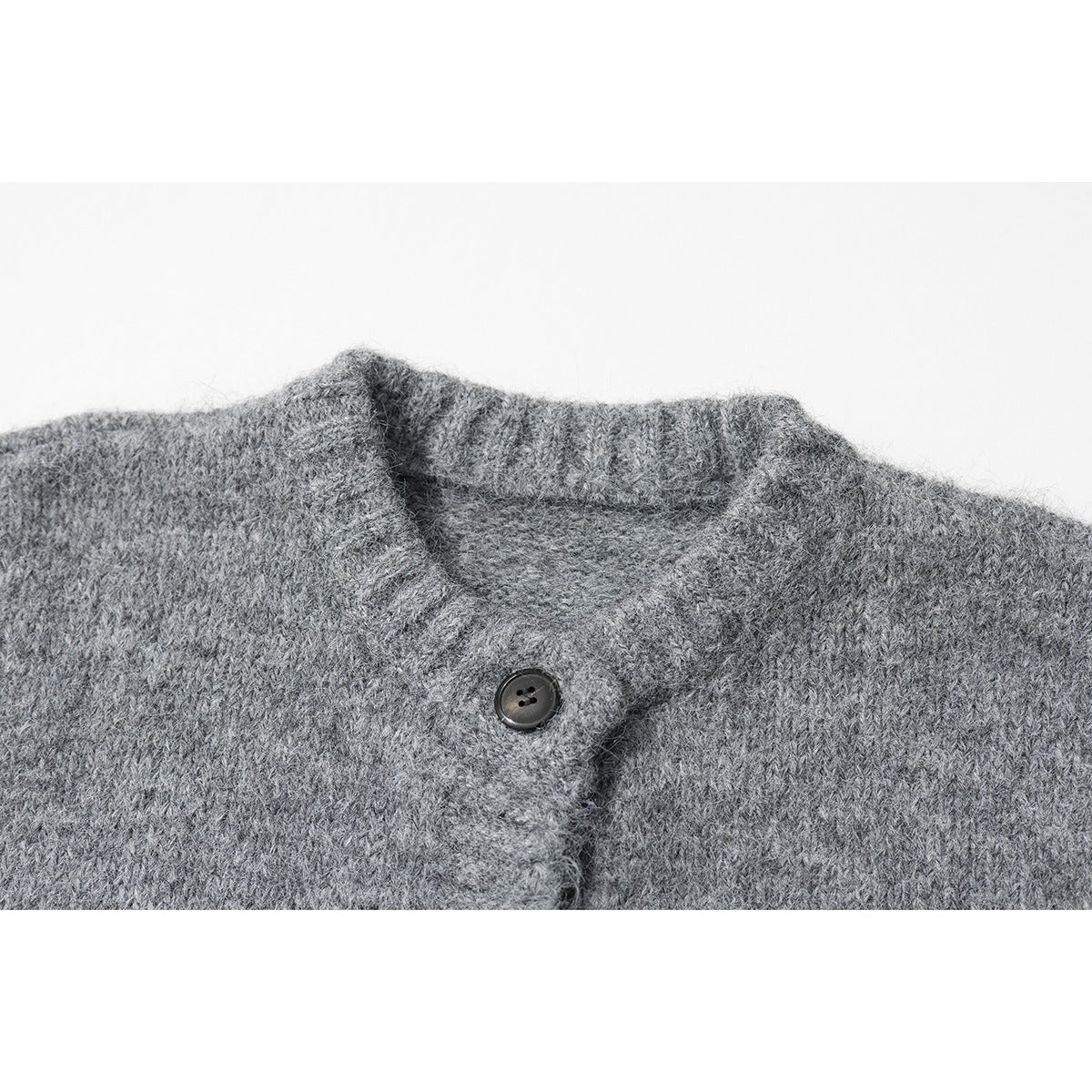 Close-up of a gray knitted cardigan's ribbed collar and dark button.
