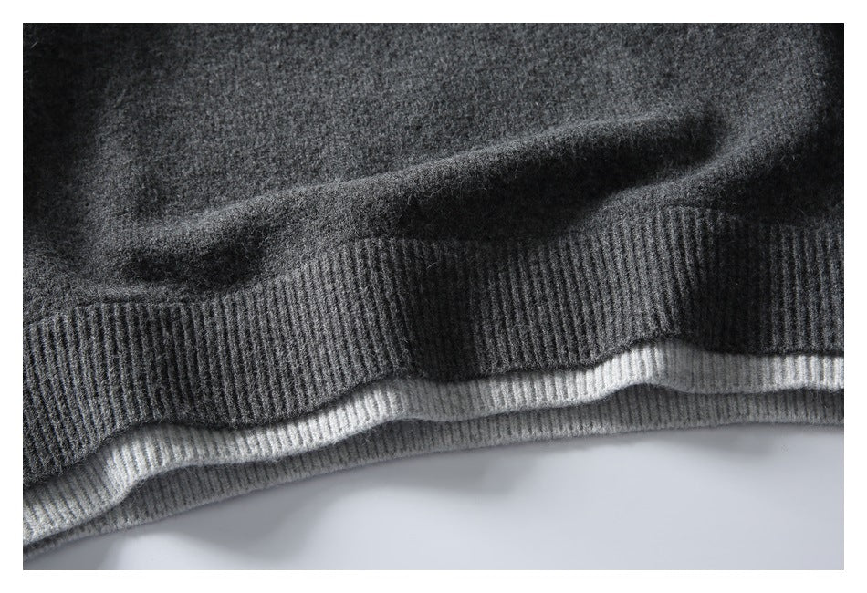 Close-up of the charcoal sweater's ribbed hem, with a light gray knit layer visible beneath.
