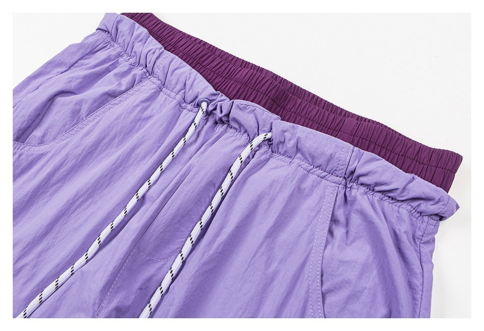 Close-up of lavender pants with a gathered waistband, dark purple elastic inner band, and white patterned drawstrings.