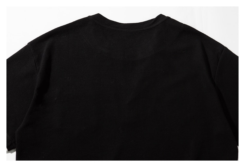 Close-up of the black shirt's upper back and crew neckline.