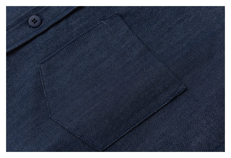 Close-up of a dark blue shirt's stitched chest pocket and a button near the placket.