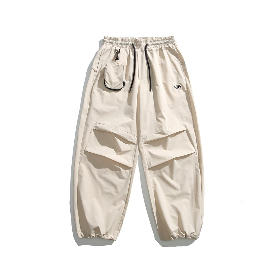 Off-white wide-leg pants with drawstring waist, clipped pouch, pleated knee panels and gathered ankle cuffs, flat lay