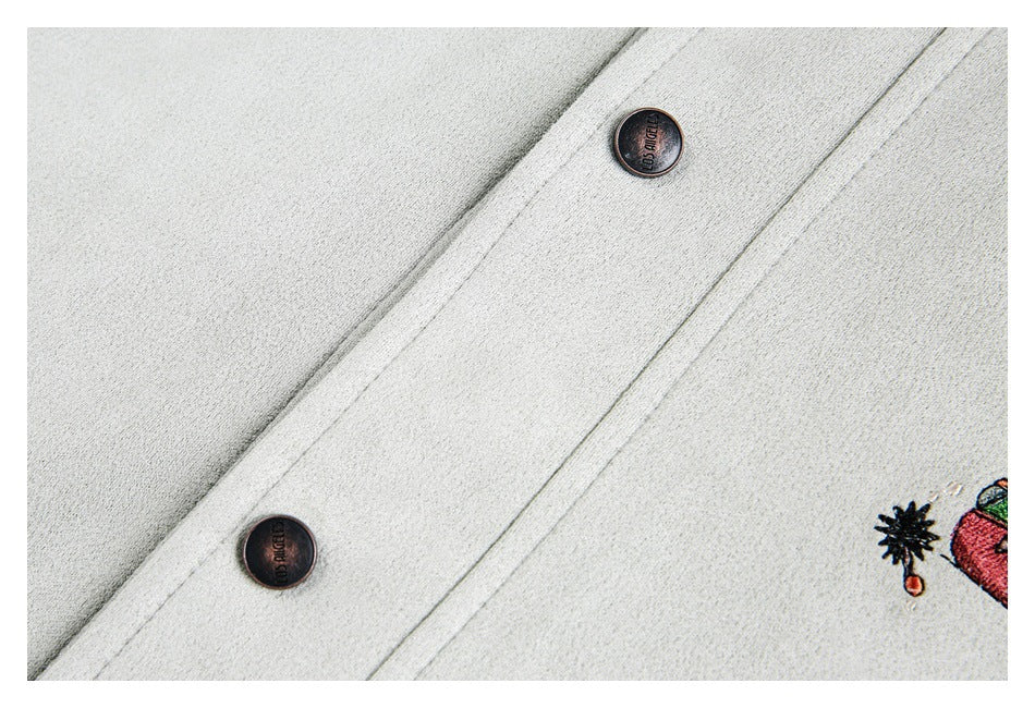 Close-up of the off-white coat front placket with two dark buttons and partial embroidery.