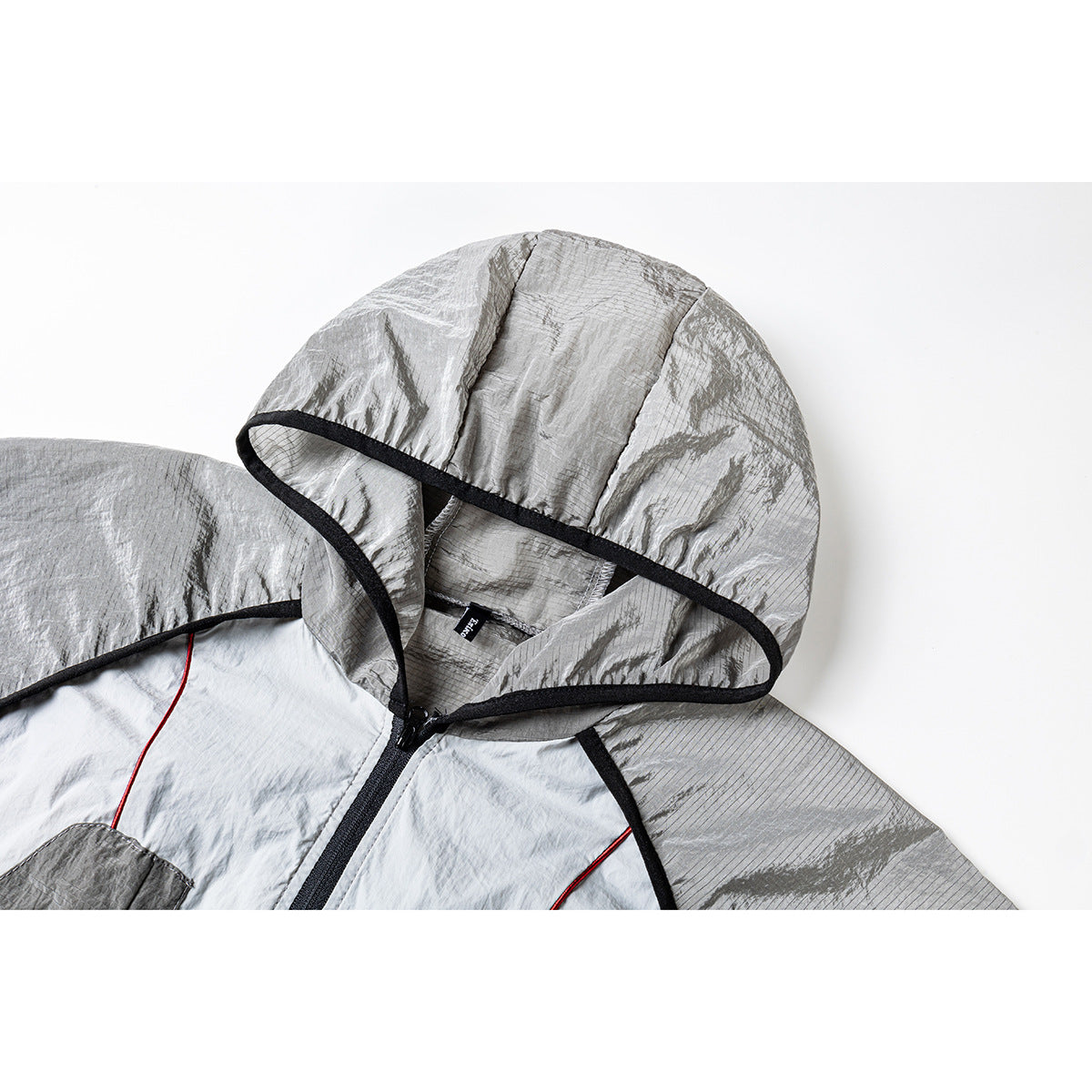 Close-up of the jacket’s silver-gray hood, black edging, zipper, and contrasting gray panels.