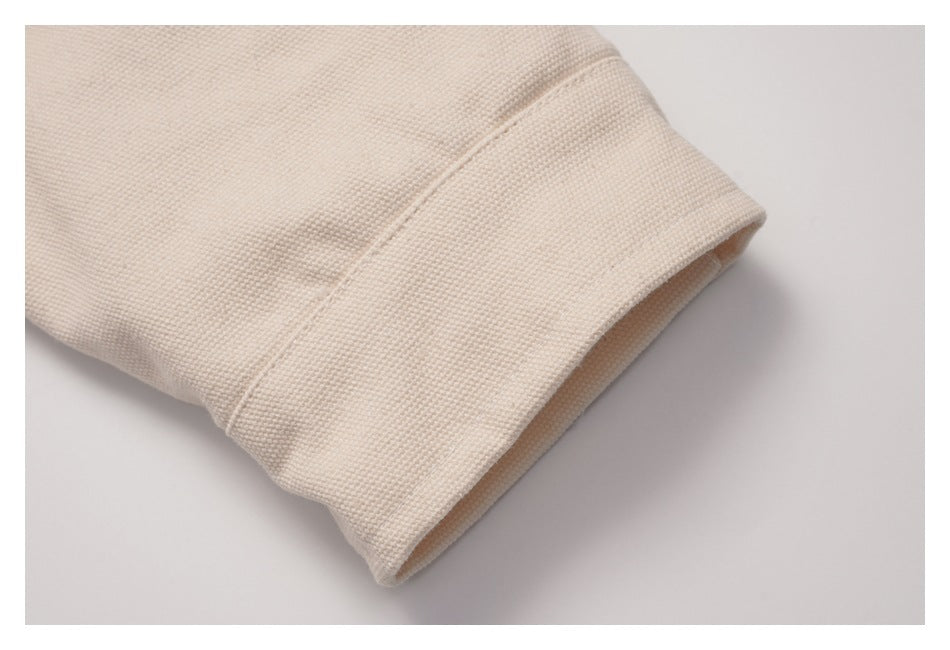 Close-up of the wide cuff and textured fabric on a beige jacket sleeve.