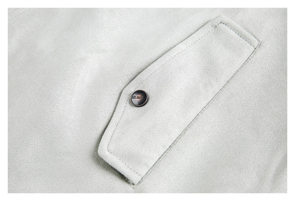 Close-up of an off-white coat pocket flap with a dark button and stitched edging.