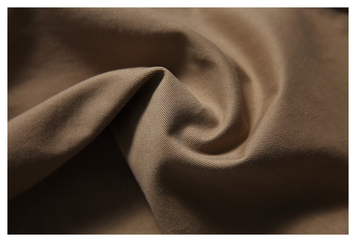 Close-up of softly folded brown fabric showing a fine diagonal weave.