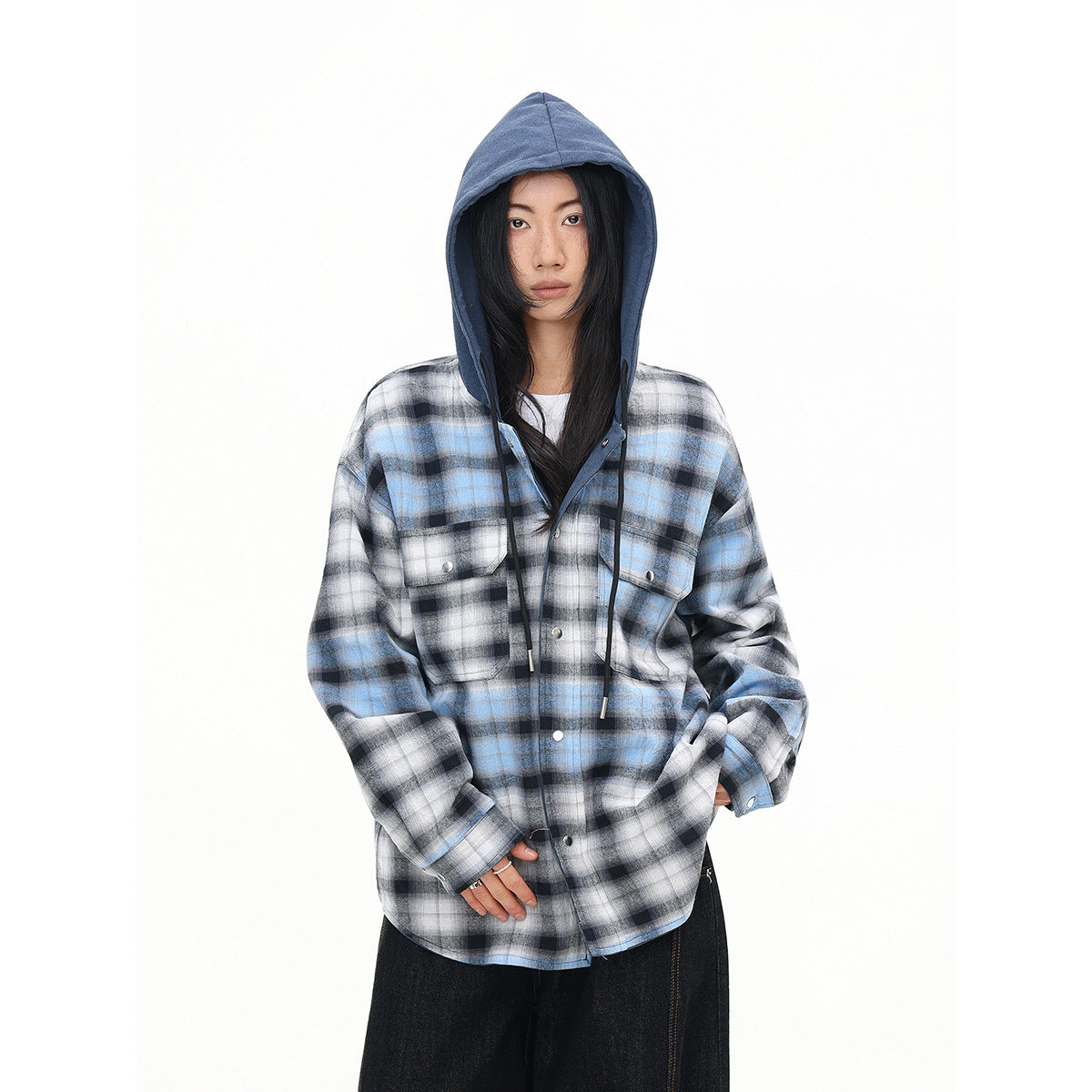Model wearing a blue, gray, and black plaid hooded button-up shirt with chest pockets.