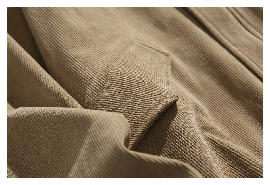 Close-up of a stitched pocket on tan corduroy fabric.