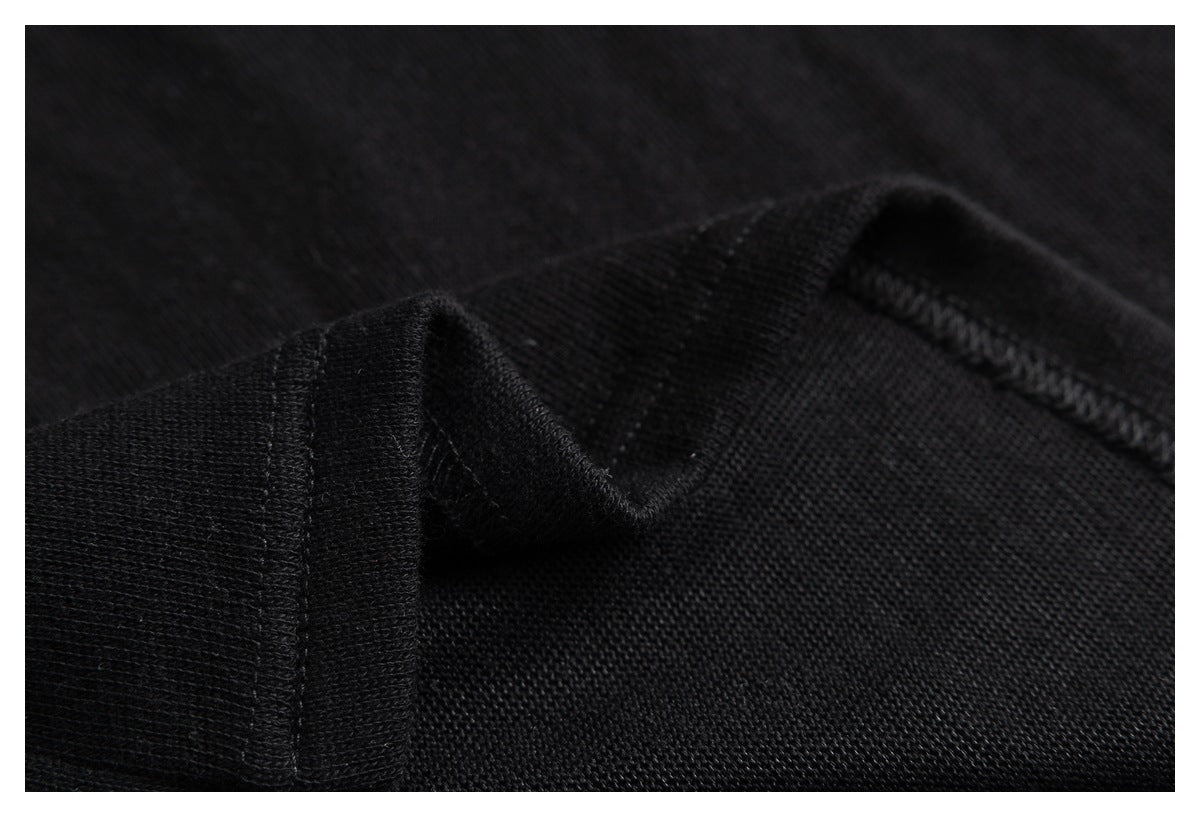 Close-up of black knit fabric with a folded seam and visible stitching.