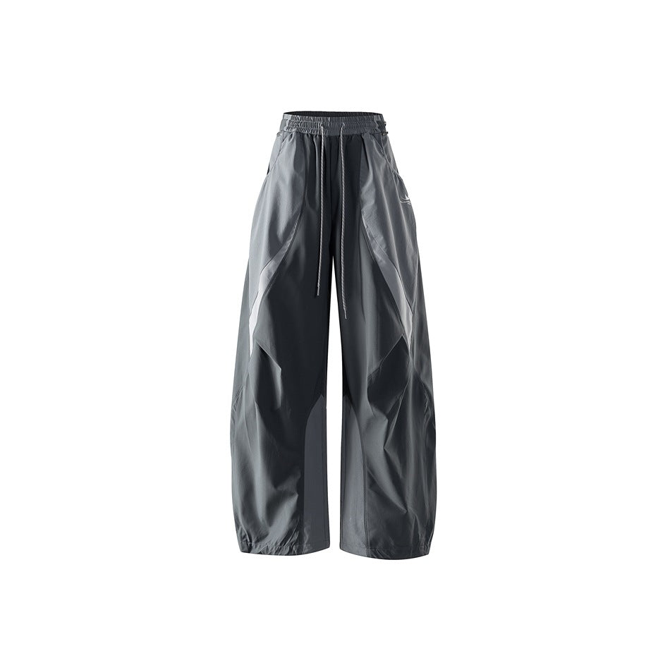 Dark gray wide-leg drawstring pants with lighter gray curved panels, shown flat from the front
