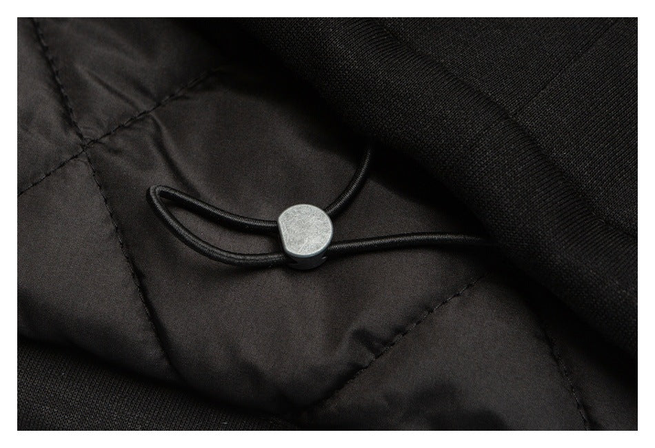 Close-up of a black drawcord toggle inside the garment beside quilted lining.