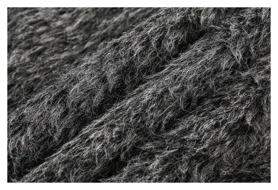 Extreme close-up of dark gray and black shaggy garment fabric.
