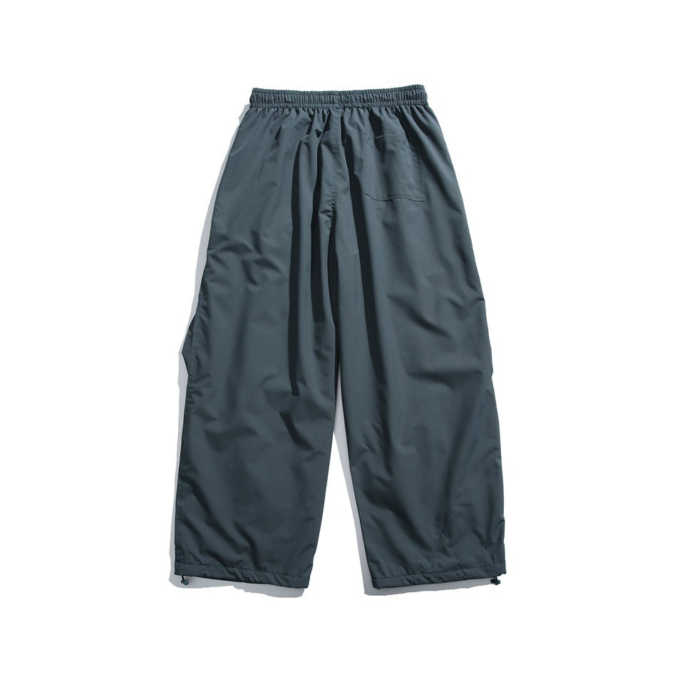 Back view of slate gray wide-leg pants with an elastic waistband, one rear pocket and adjustable ankle hems.