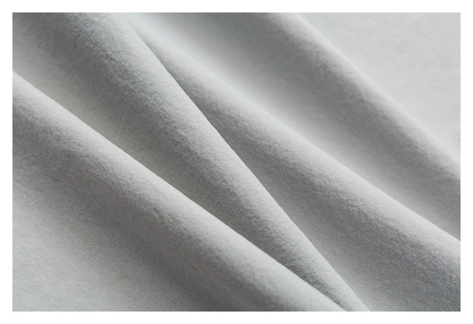 Close-up of the soft-looking, lightly textured light gray shorts fabric.