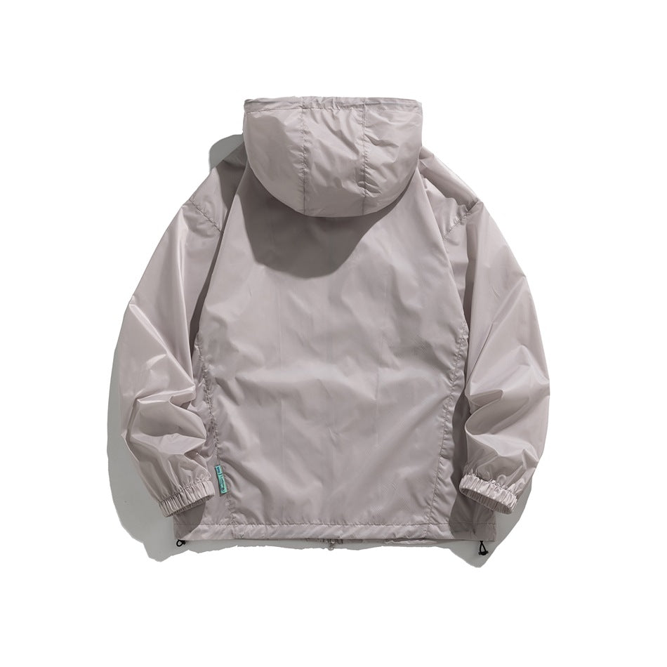 Back view of a light taupe hooded jacket with elastic cuffs and a small turquoise side label.