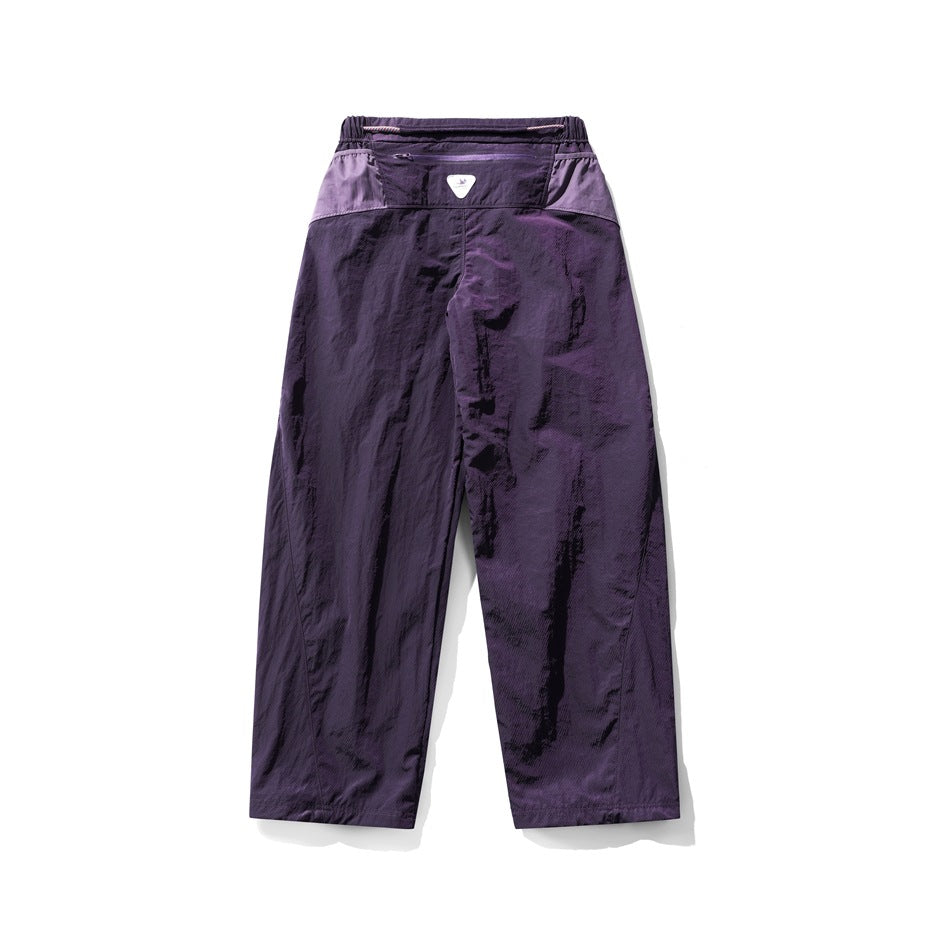 Back view of loose deep-purple pants with a lighter purple waistband panel and elastic waist.