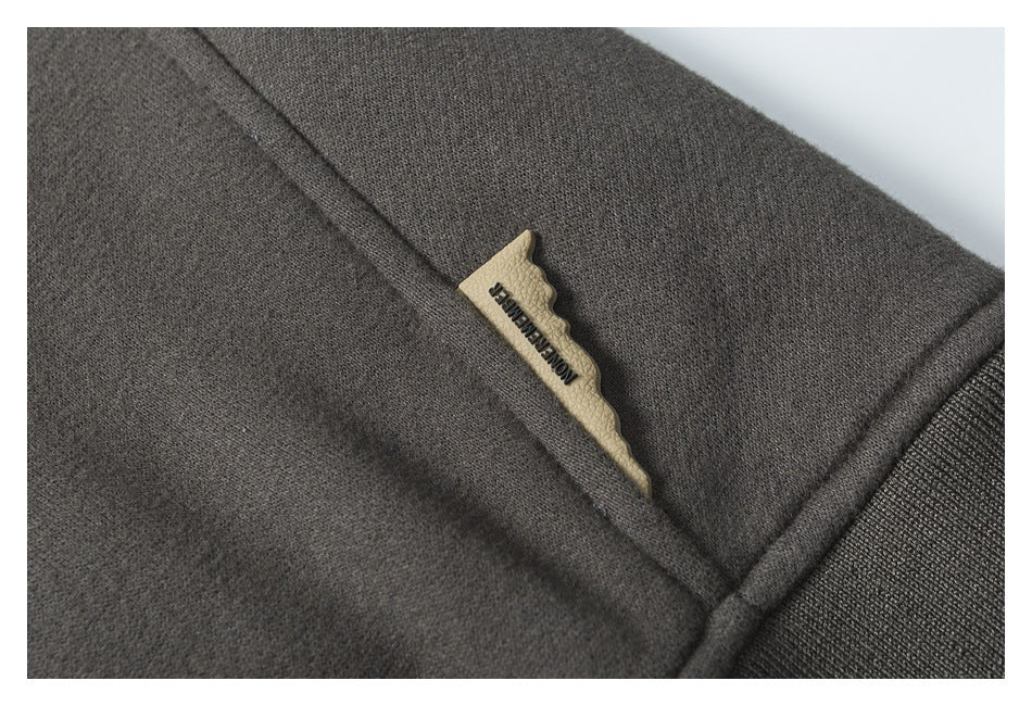 Close-up of a small tan label tucked into a seam on a dark charcoal garment.