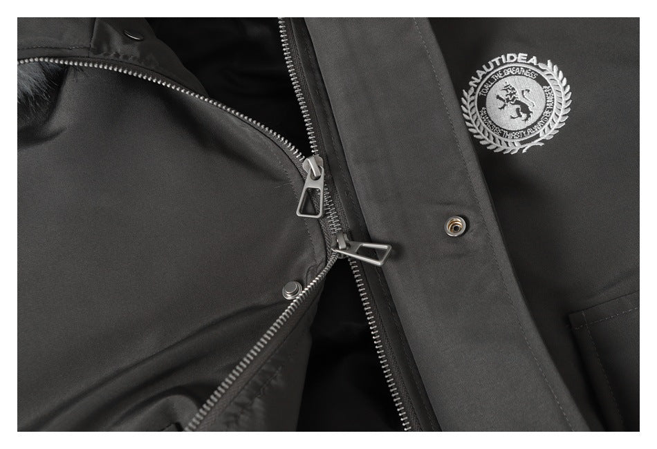 Close-up of the jacket’s front zipper and snap placket beside an embroidered chest emblem.
