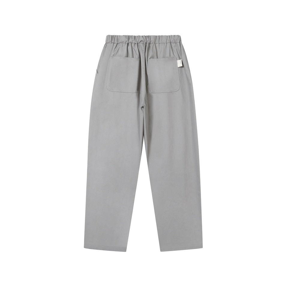 Back view of gray elastic-waist pants with two patch pockets and a small tag at the waistband