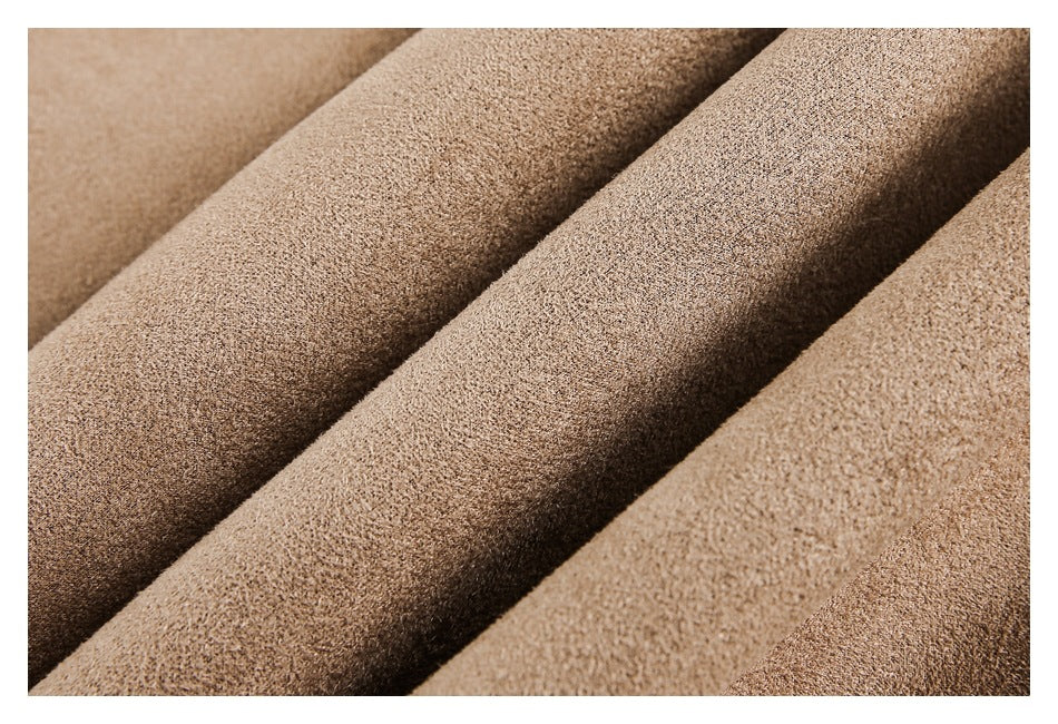 Close-up of textured tan fabric arranged in soft folds.