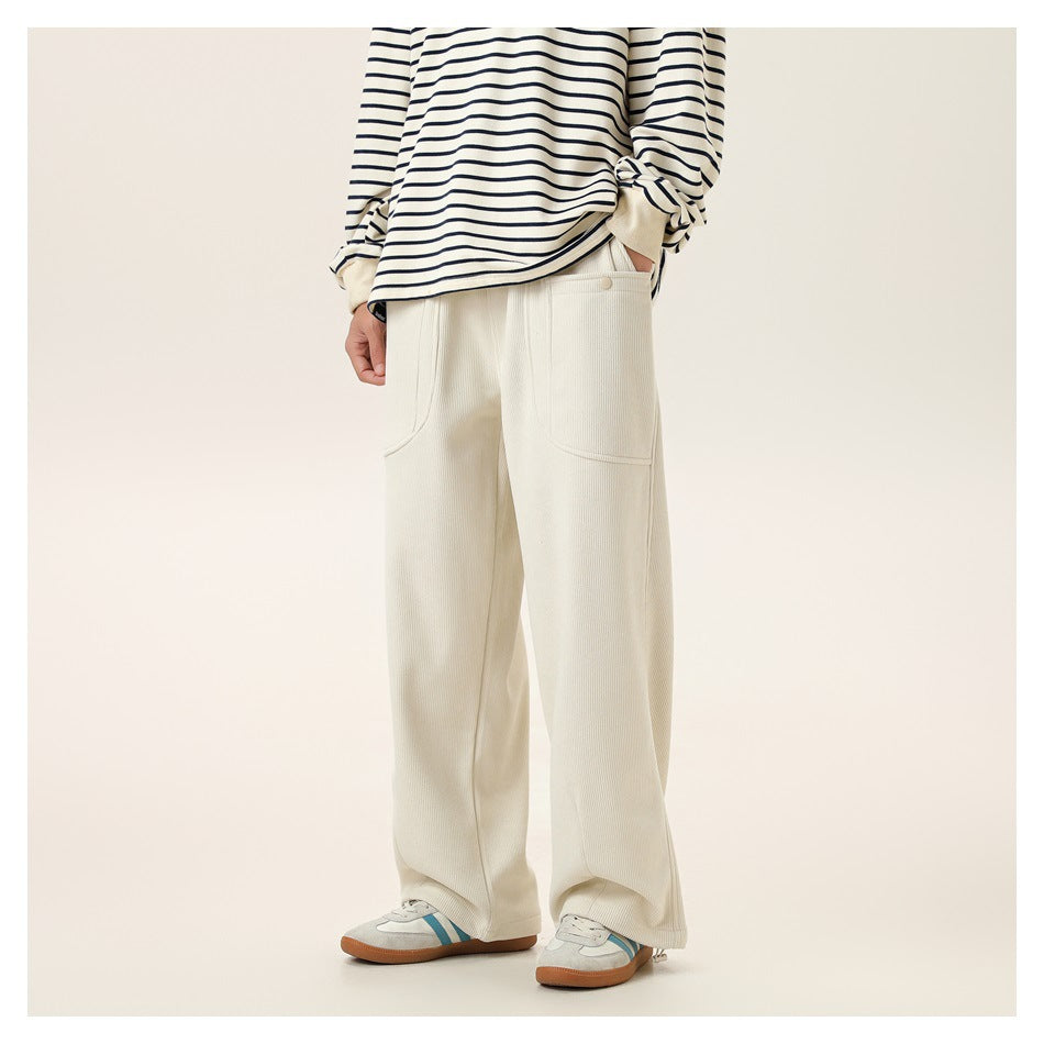 Model wearing cream ribbed wide-leg pants with a snap-button front pocket and a striped long-sleeve top