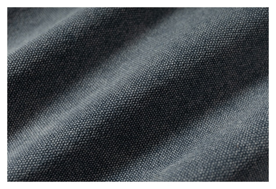 Macro view of the dark blue-gray woven denim surface and its textured weave.