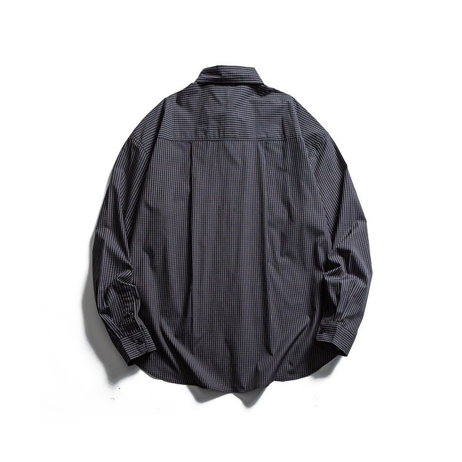 Back of a dark charcoal checked button-up shirt laid flat, with a yoke seam and center pleat.