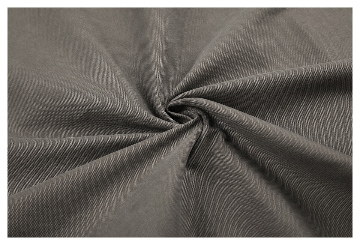 Close-up of charcoal-gray fabric twisted to show its fine textured surface.