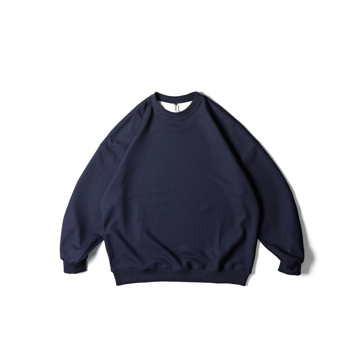 Navy blue crew neck sweatshirt with drop shoulders and ribbed cuffs and hem, flat lay front view