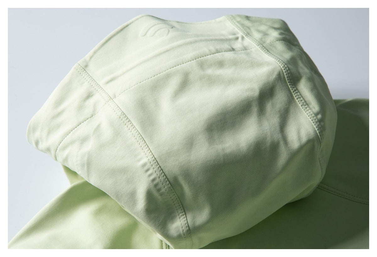 Close-up of pale green garment panels with curved stitched seams.